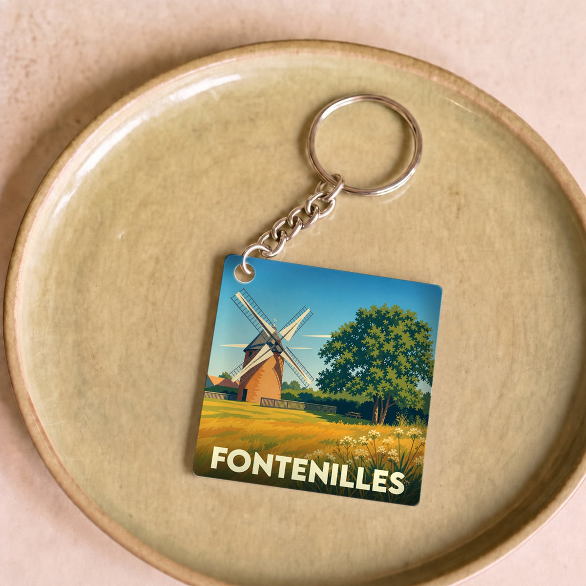 Porte-clés souvenir de la ville de Fontenilles avec une illustration stylisée d'un moulin.