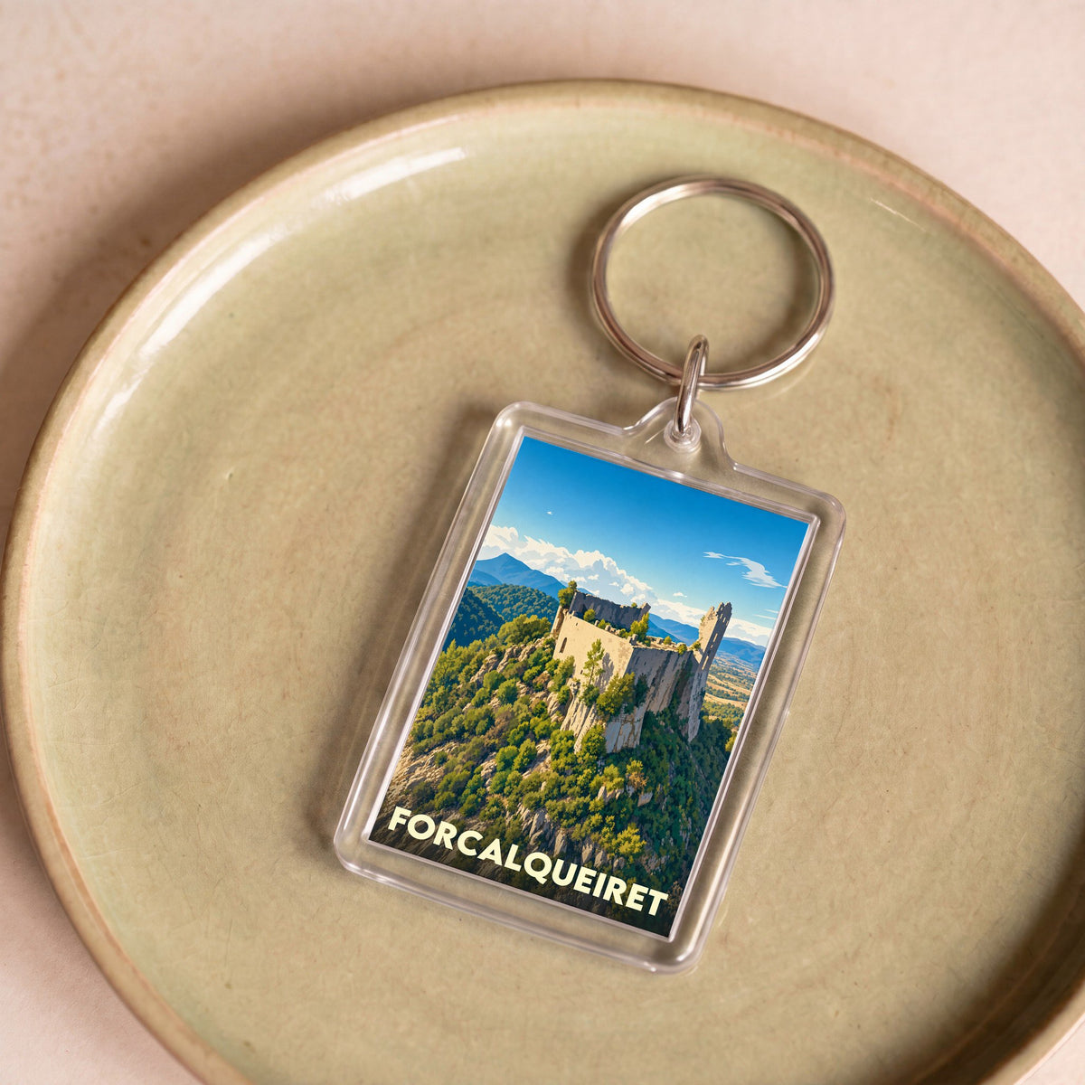 Porte-clés souvenir de la ville de Forcalqueiret avec une illustration stylisée du château sur sa colline.