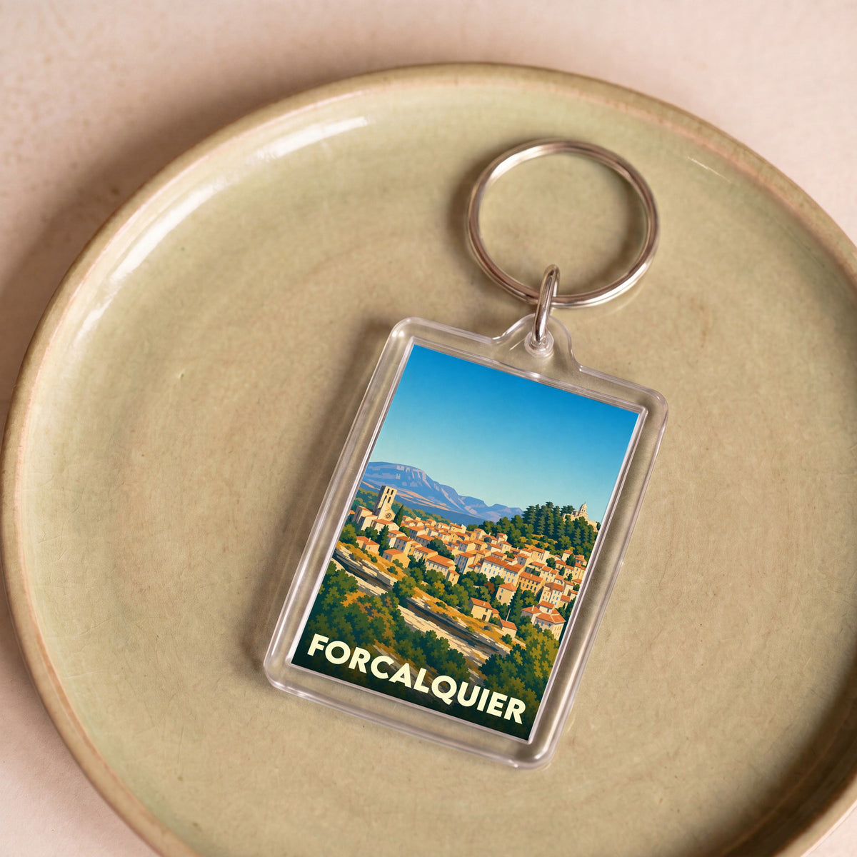 Porte-clés souvenir de la ville de Forcalquier avec une illustration stylisée.
