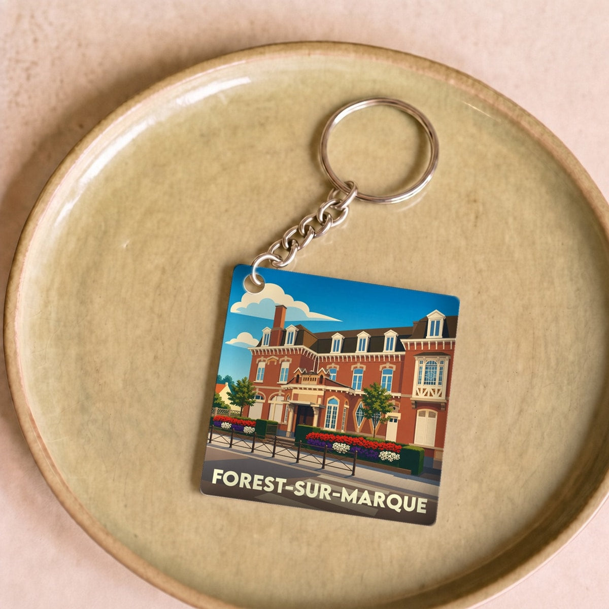 Porte-clés souvenir de la ville de Forest-sur-Marque avec une illustration stylisée de sa mairie.