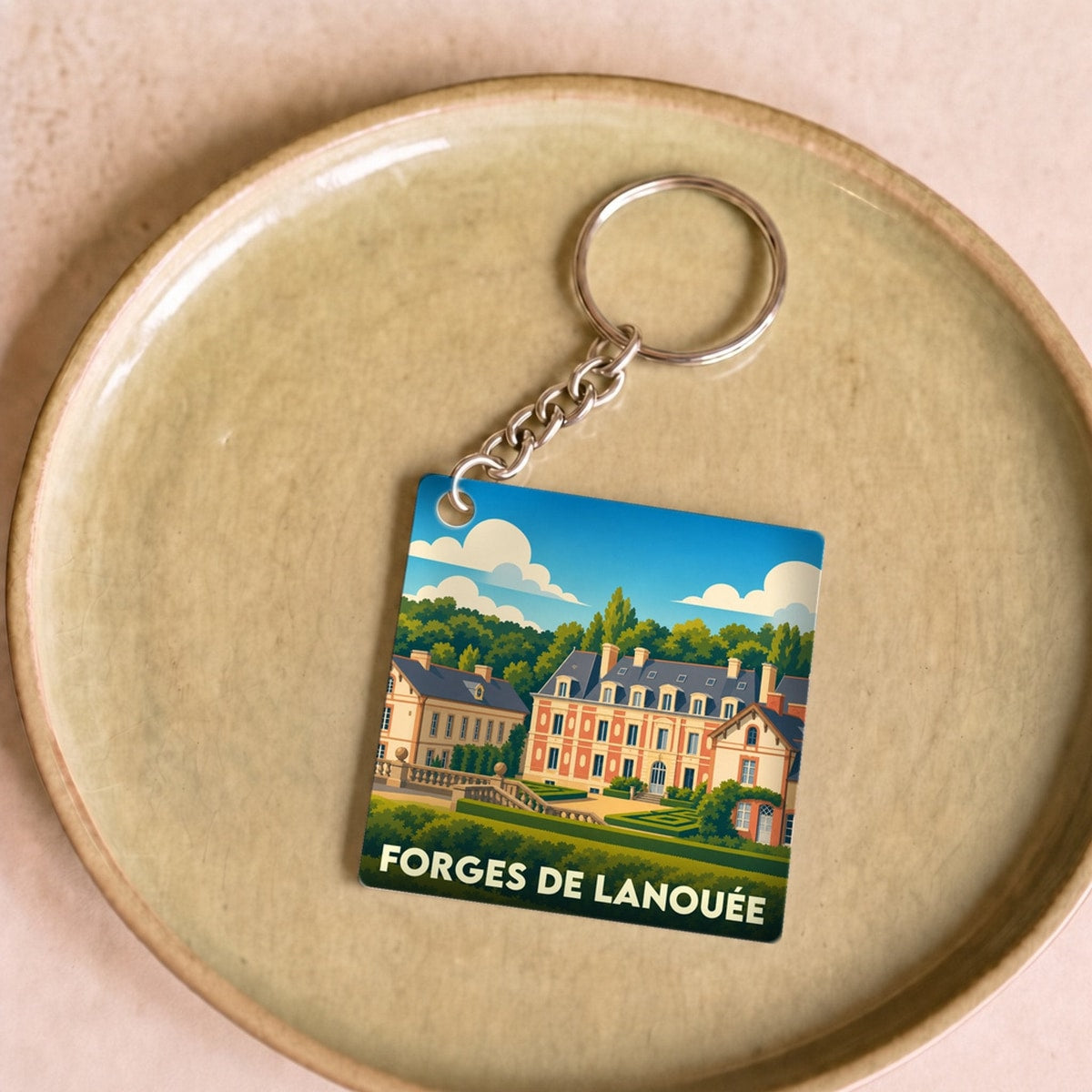 Porte-clés souvenir de la ville de Forges de Lanouée avec une illustration stylisée de son château.