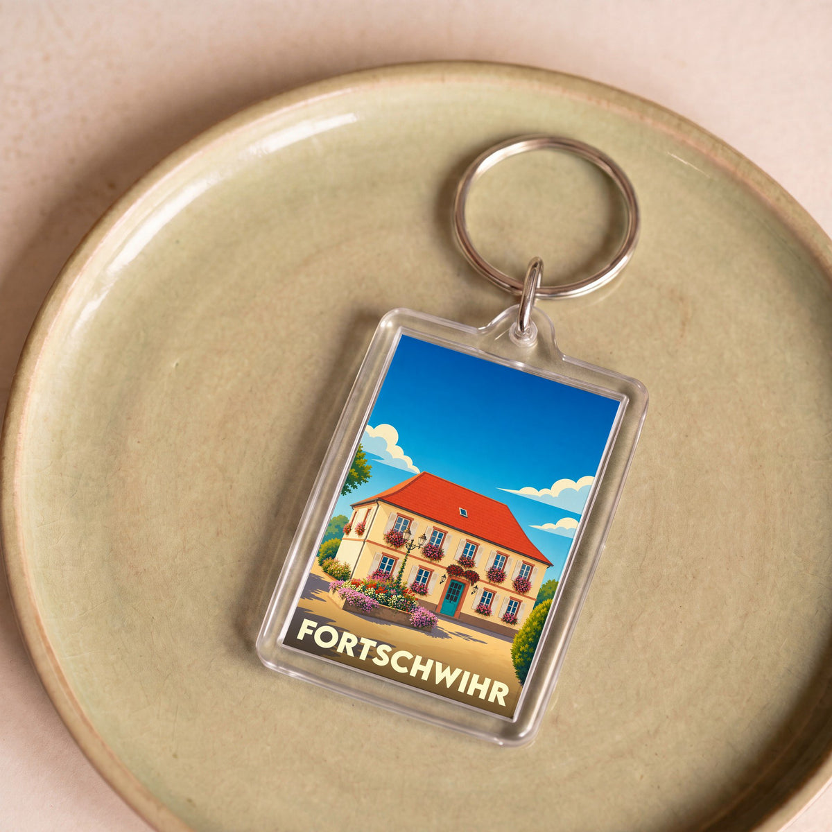 Porte-clés souvenir de la ville de Fortschwihr avec une illustration stylisée d'une maison alsacienne fleurie.