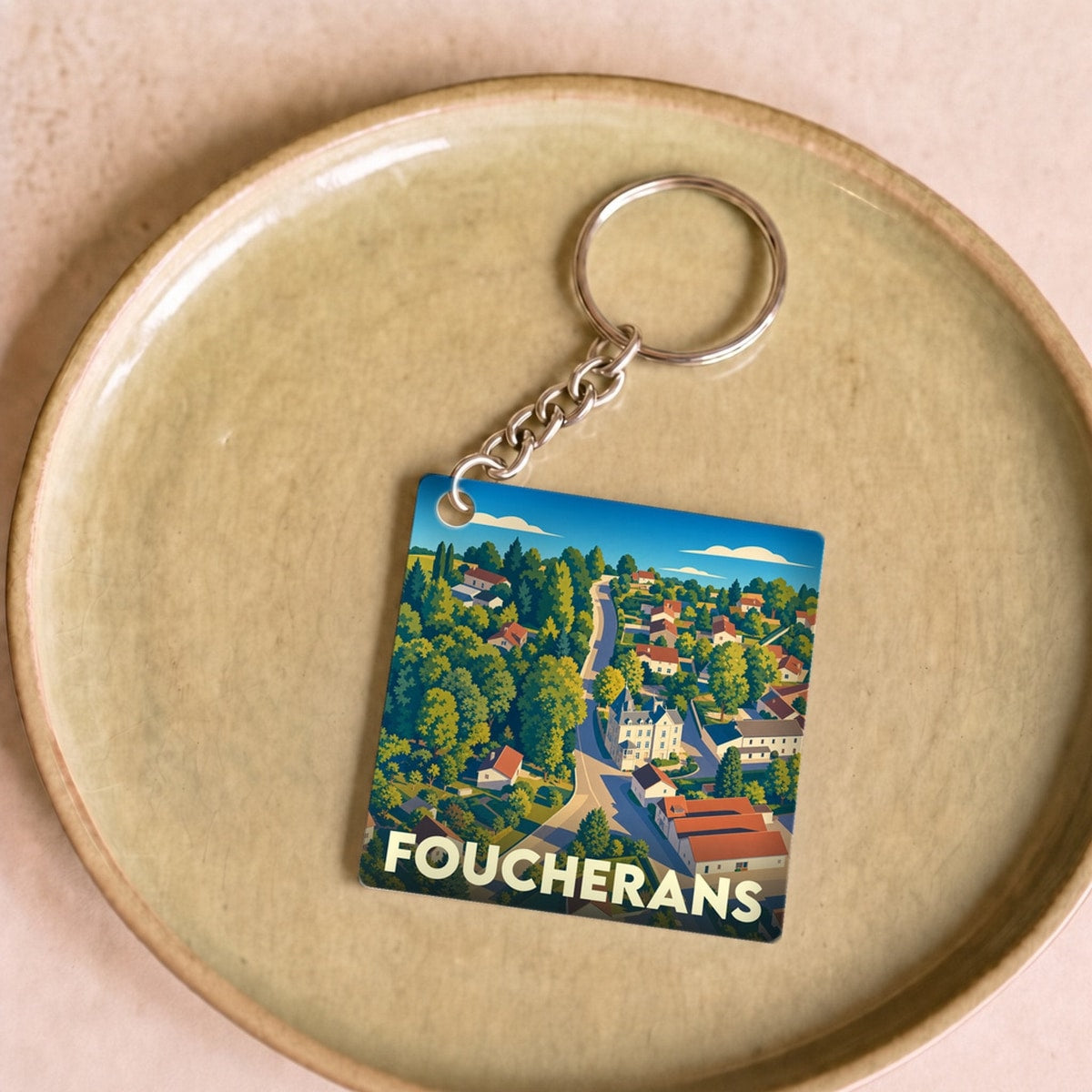 Porte-clés souvenir de la ville de Foucherans avec une illustration stylisée.