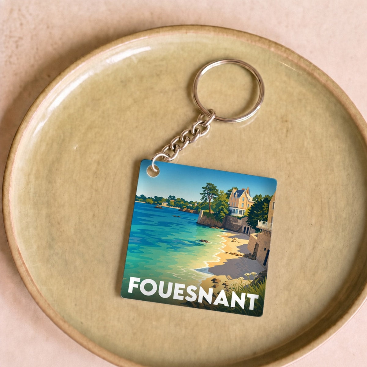 Porte-clés souvenir de la ville de Fouesnant avec une illustration stylisée du bord de mer.