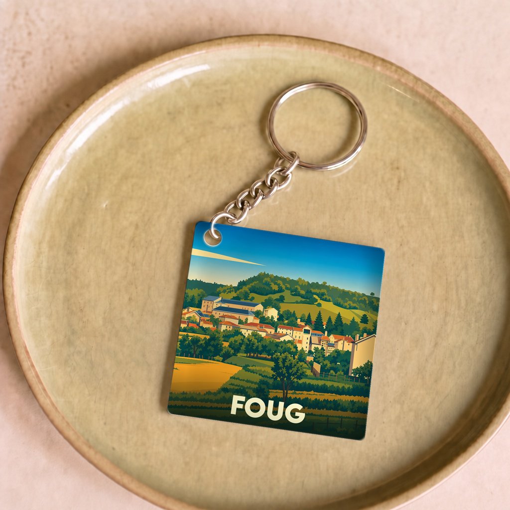 Porte-clés souvenir de la ville de Foug avec une illustration stylisée de son paysage.