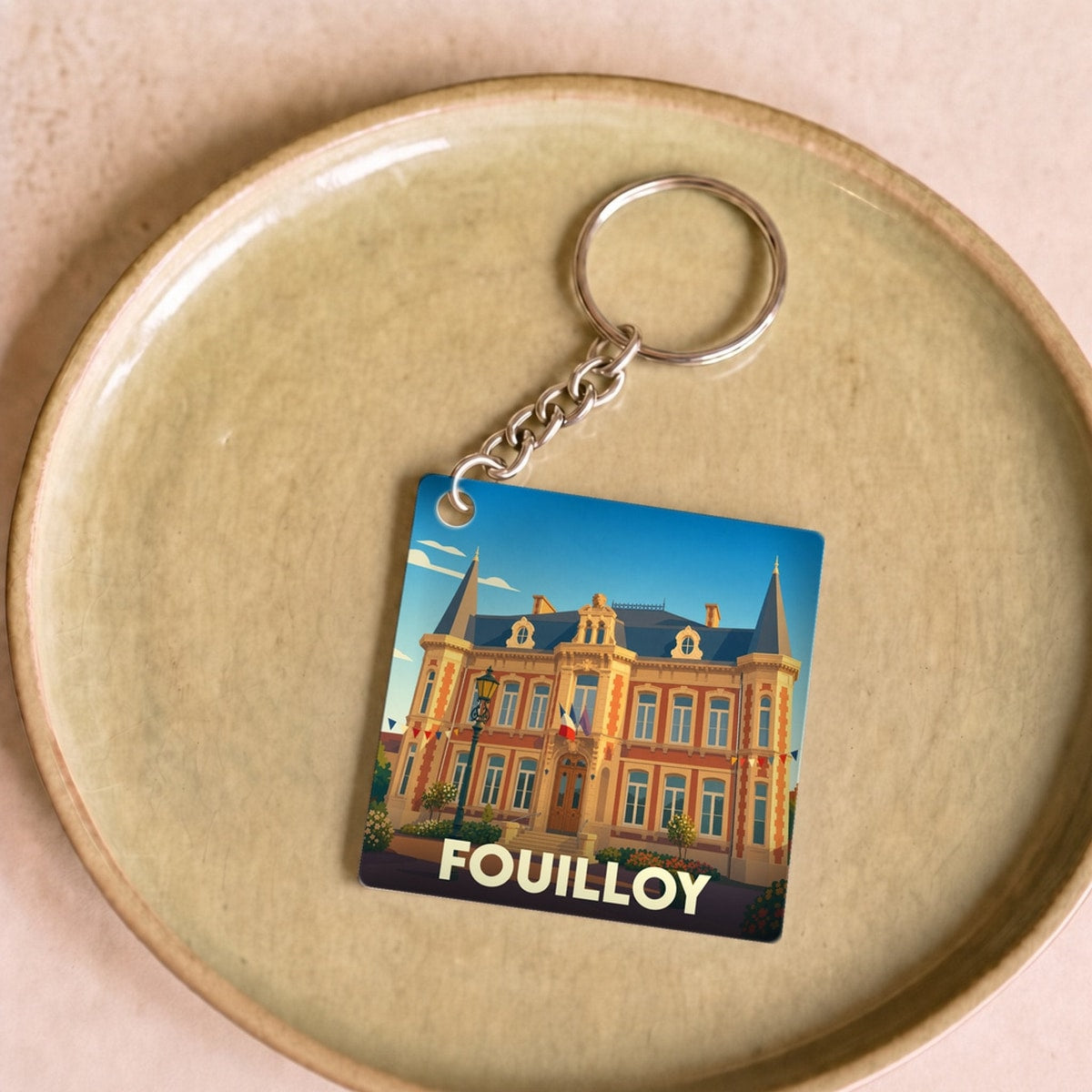 Porte-clés souvenir de la ville de Fouilloy avec une illustration stylisée de sa mairie.