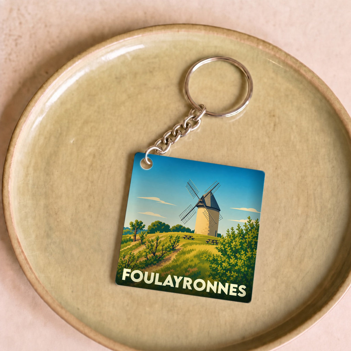 Porte-clés souvenir de la ville de Foulayronnes avec une illustration stylisée d'un moulin.