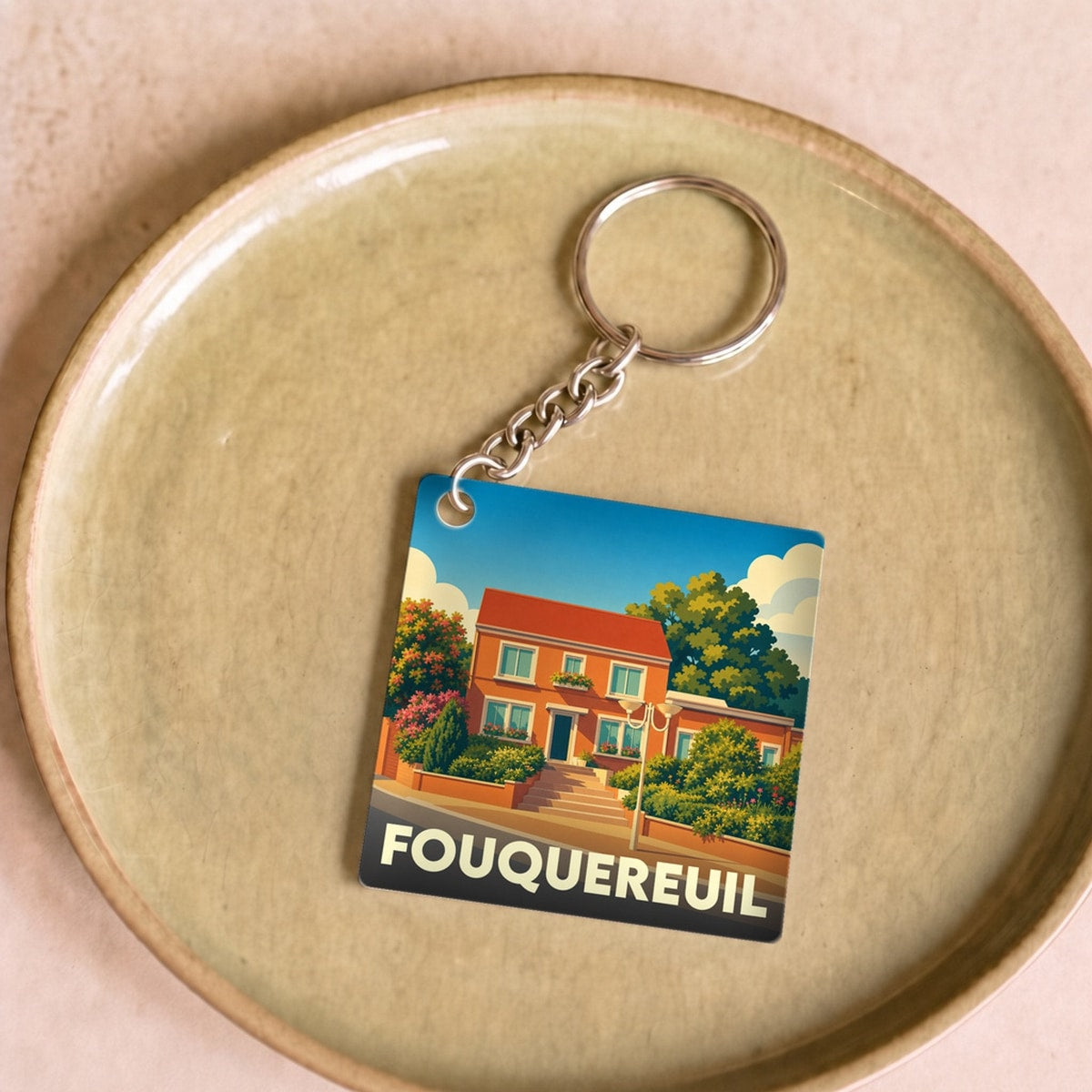Porte-clés souvenir de la ville de Fouquereuil avec une illustration colorée et stylisée d'une maison.