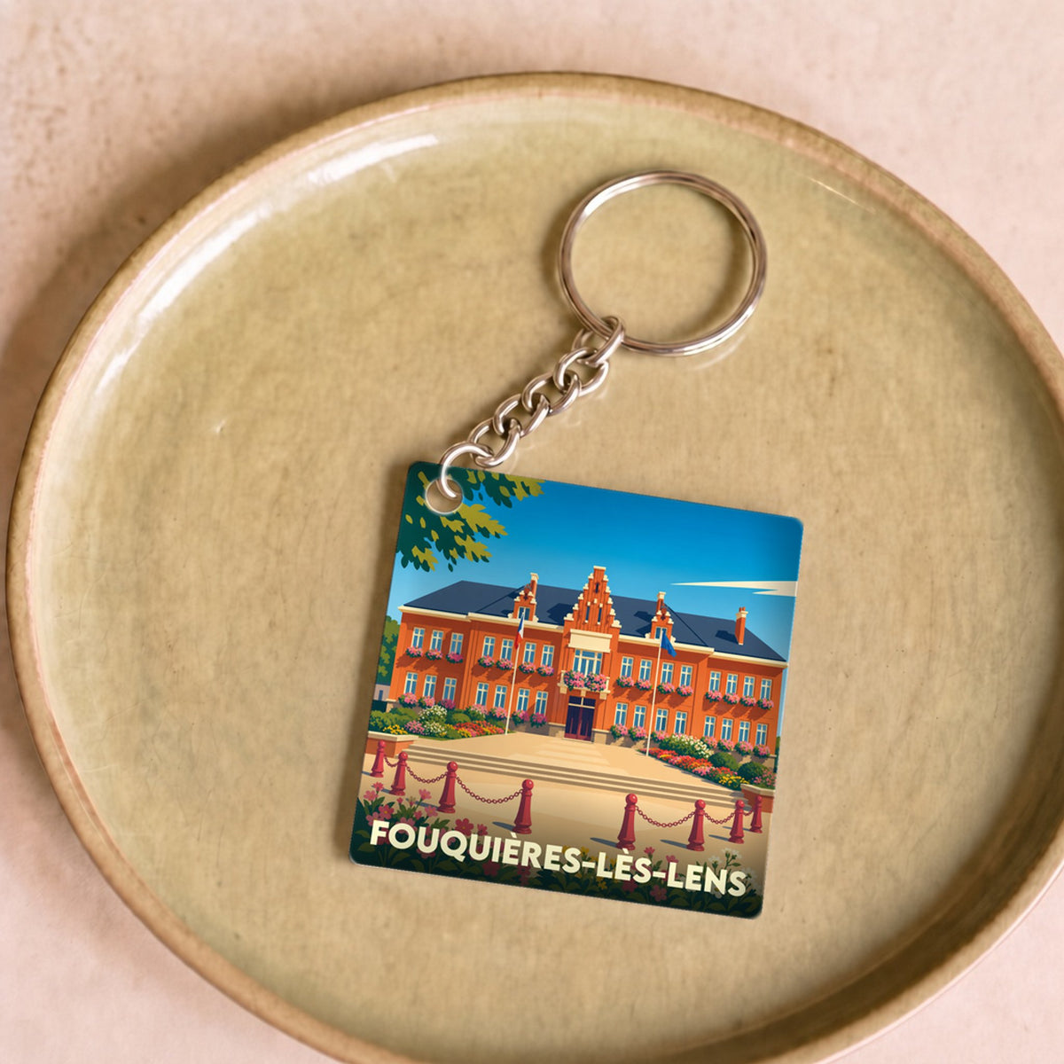 Porte-clés souvenir de la ville de Fouquières-lès-Lens avec une illustration stylisée de son hôtel de ville.