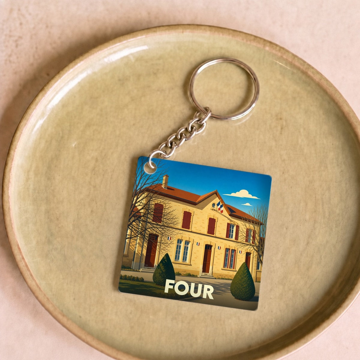 Porte-clés souvenir de la ville de Four avec une illustration stylisée d'un bâtiment officiel.