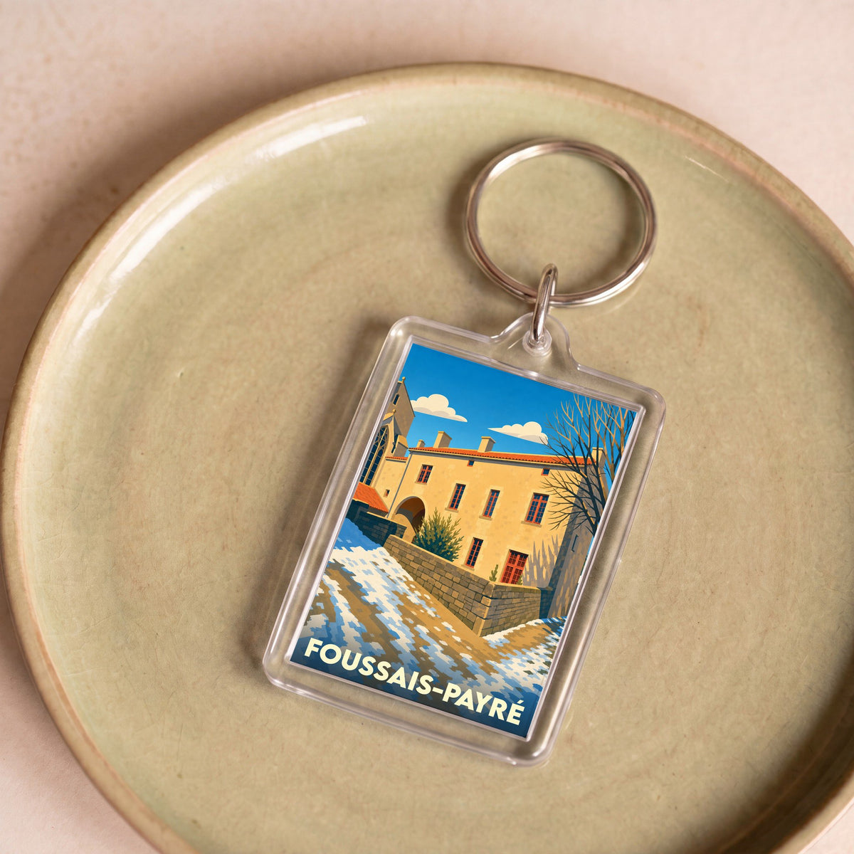 Porte-clés souvenir de la ville de Foussais-Payré avec une illustration stylisée.