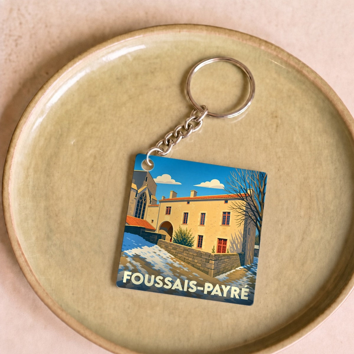 Porte-clés souvenir de la ville de Foussais-Payré avec une illustration stylisée.