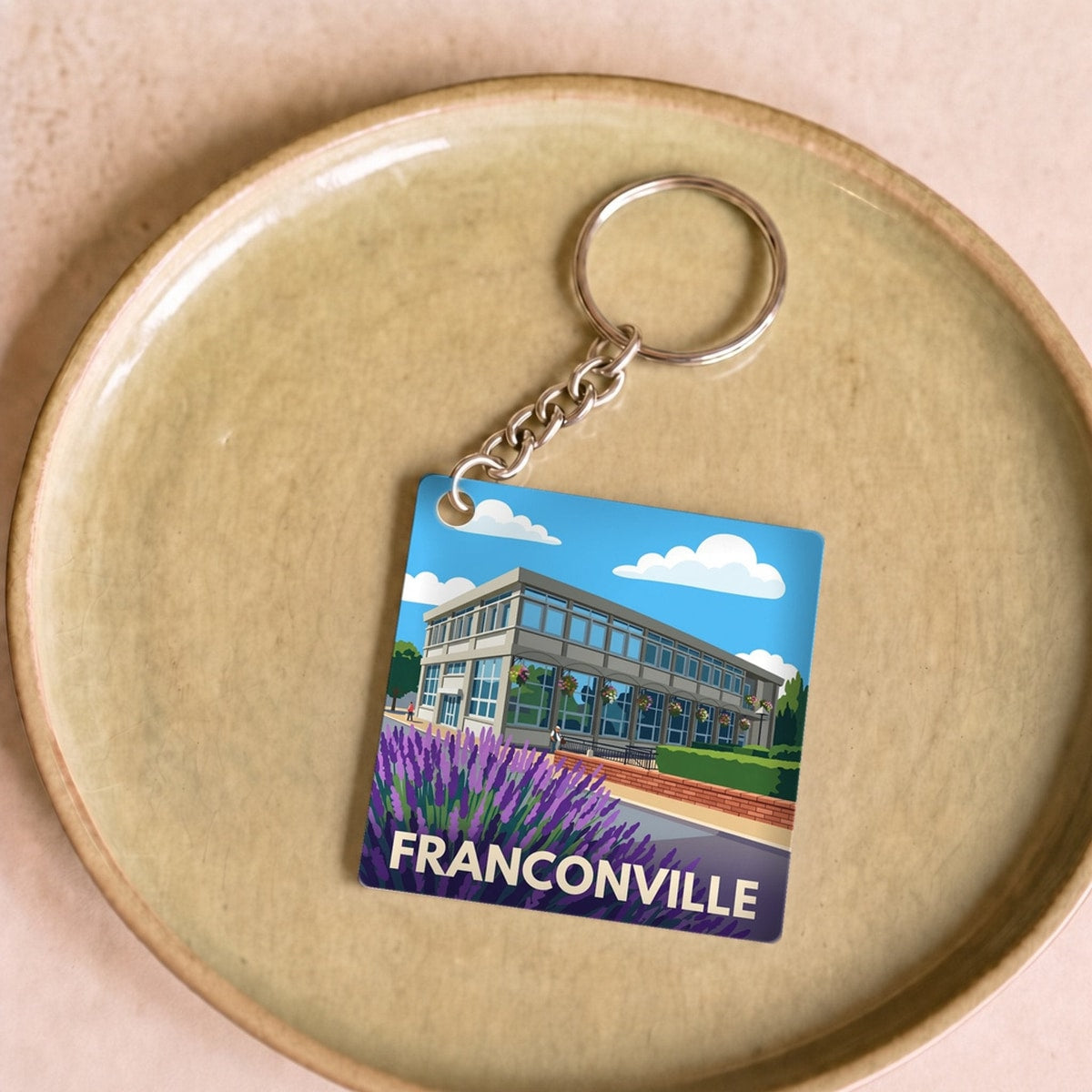 Porte-clés souvenir de la ville de Franconville avec une illustration stylisée.