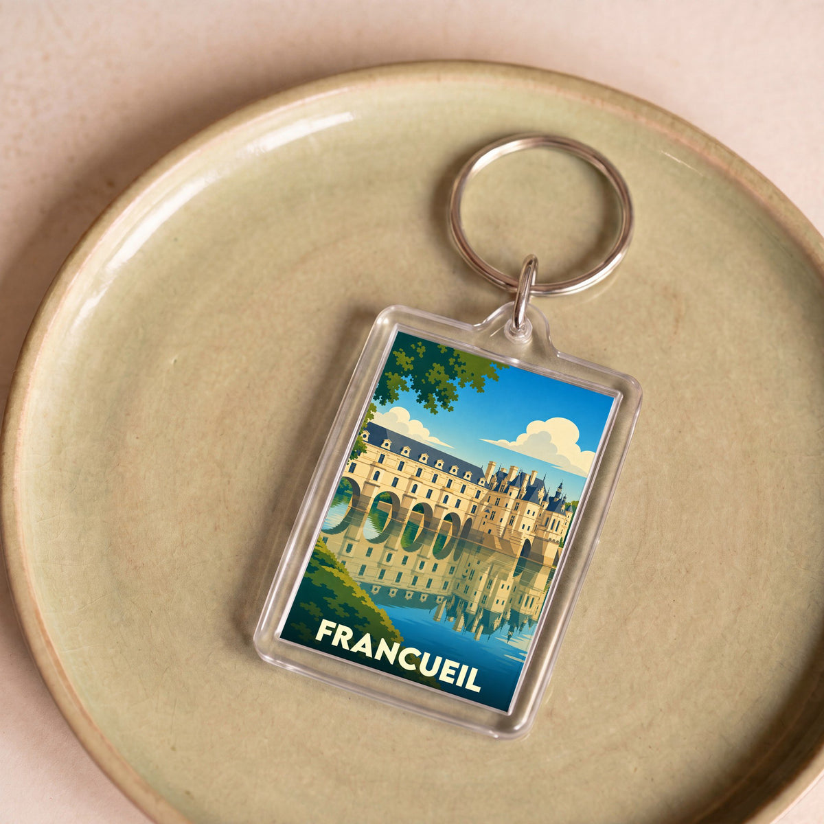 Porte-clés souvenir de la ville de Francueil avec une illustration stylisée du château de Chenonceau.