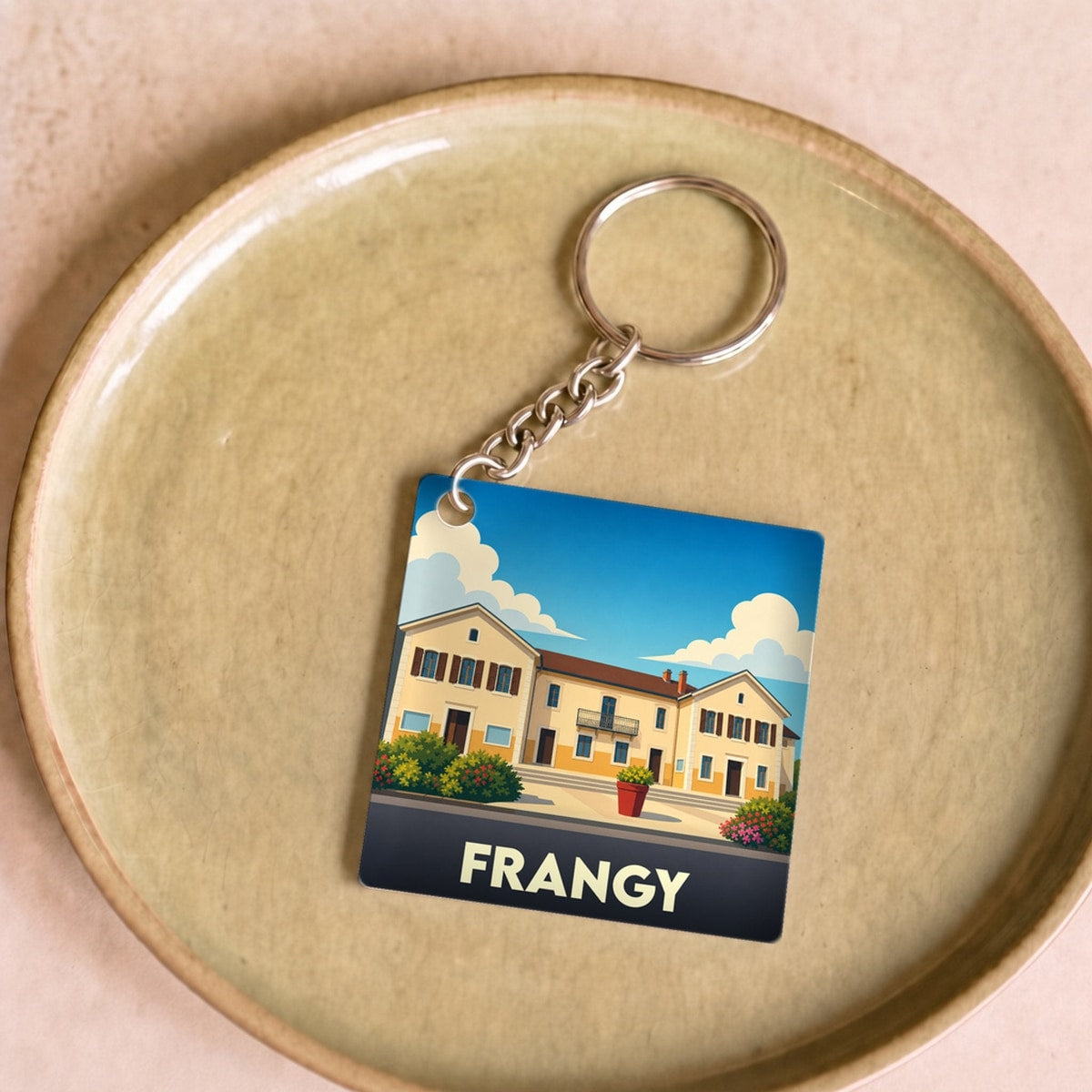 Porte-clés souvenir de la ville de Frangy avec une illustration stylisée.