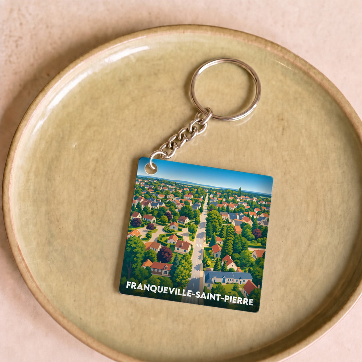 Porte-clés souvenir de la ville de Franqueville-Saint-Pierre avec une illustration stylisée vue du ciel.