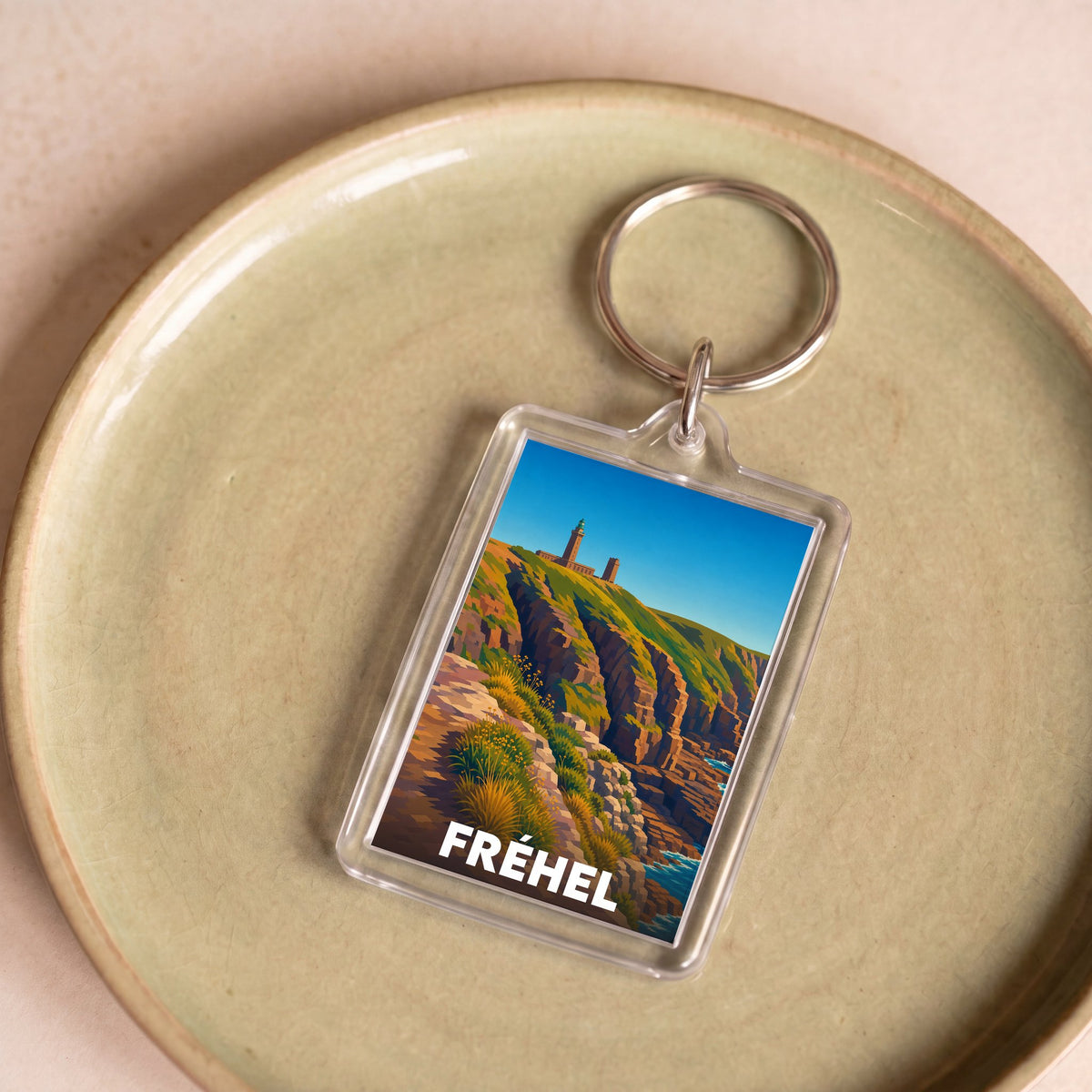Porte-clés souvenir de la ville de Fréhel avec une illustration stylisée.