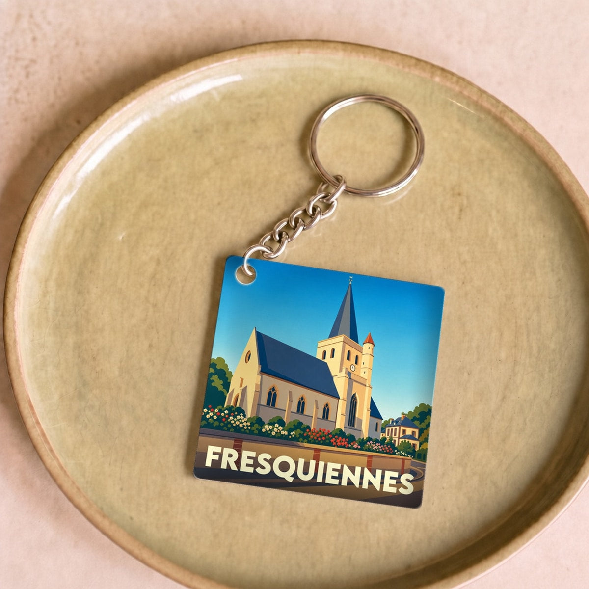 Porte-clés souvenir de la ville de Fresquiennes avec une illustration stylisée de son église.