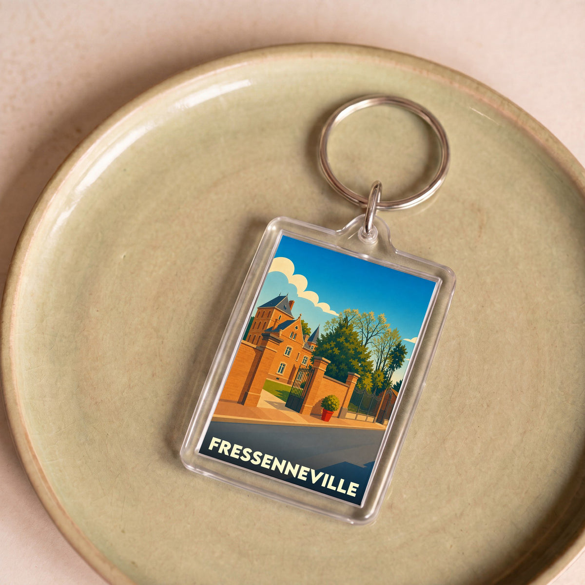 Porte-clés souvenir de la ville de Fressenneville avec une illustration stylisée.