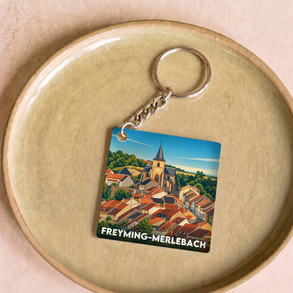 Porte-clés souvenir de la ville de Freyming-Merlebach avec une illustration stylisée.