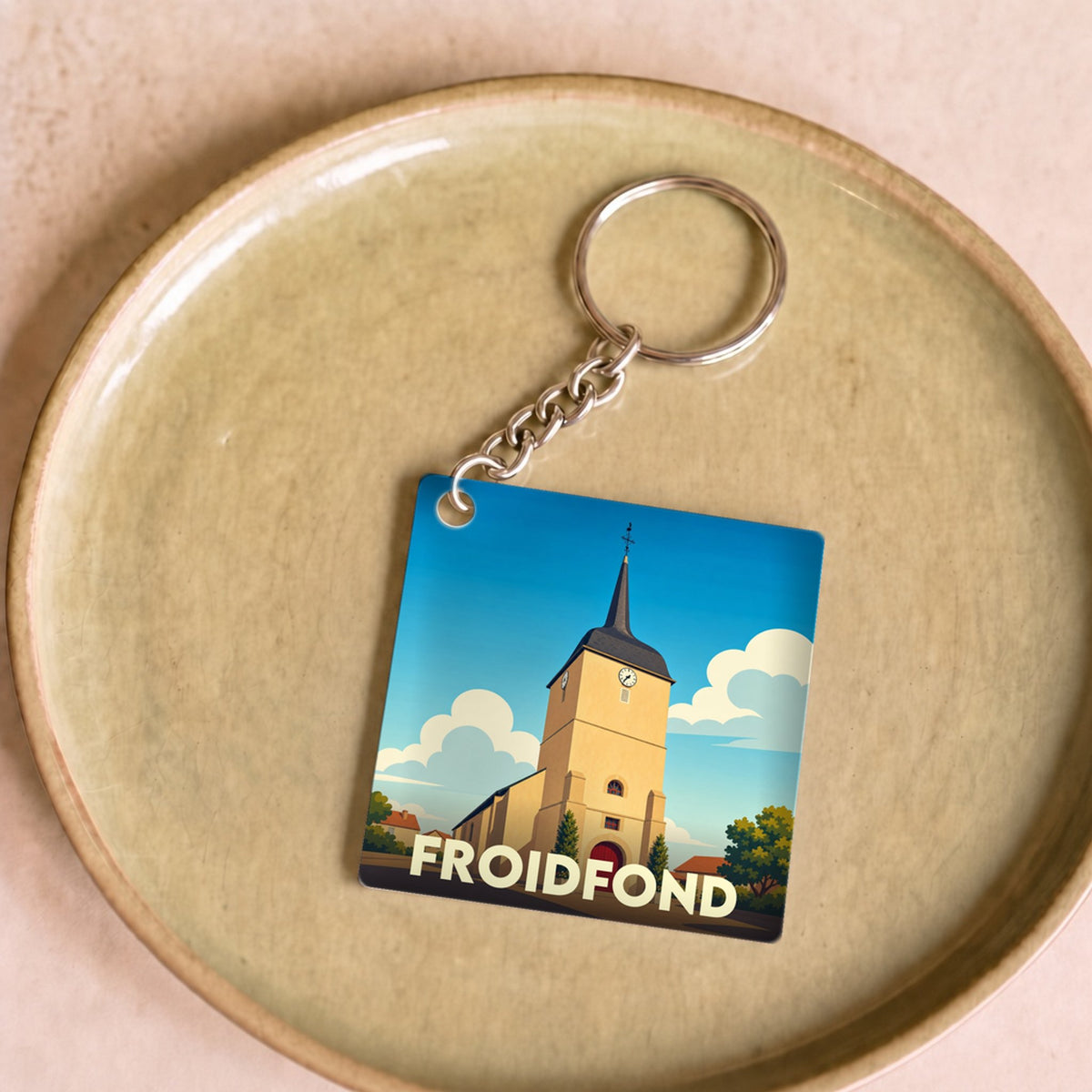 Porte-clés souvenir de la ville de Froidfond avec une illustration stylisée de son église.