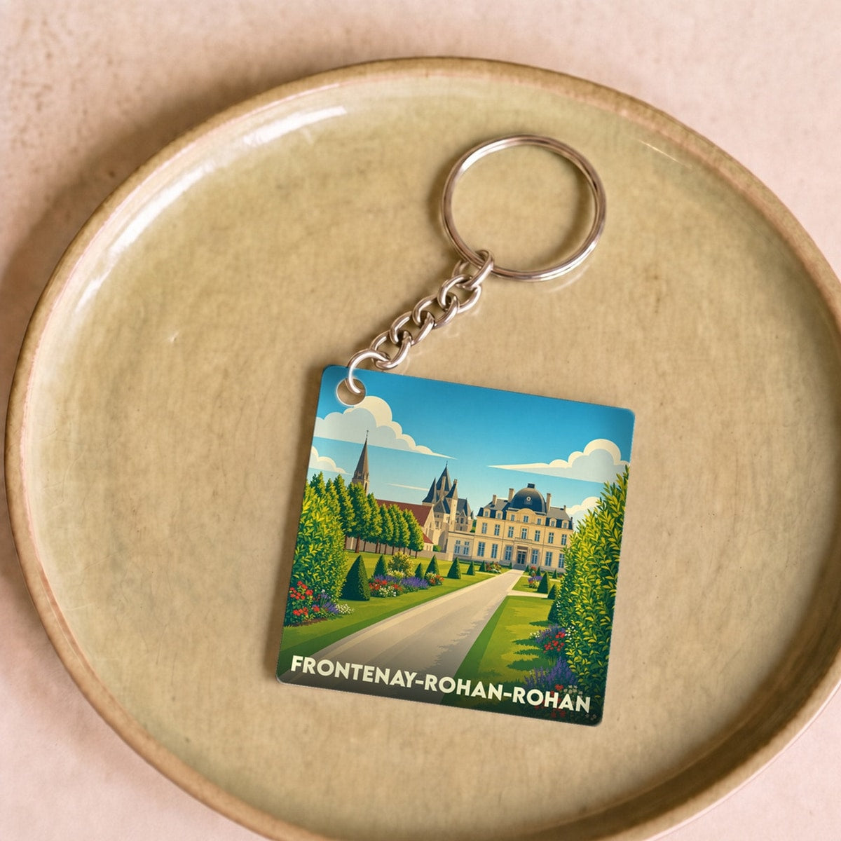 Porte-clés souvenir de Frontenay-Rohan-Rohan avec une illustration stylisée de son château et de ses jardins.