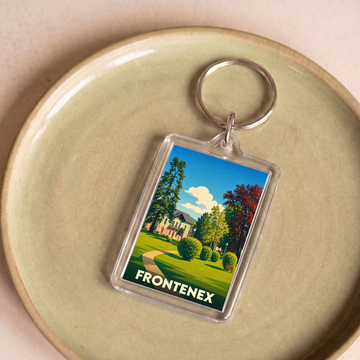 Porte-clés souvenir de la ville de Frontenex avec une illustration stylisée d'un parc paysager.
