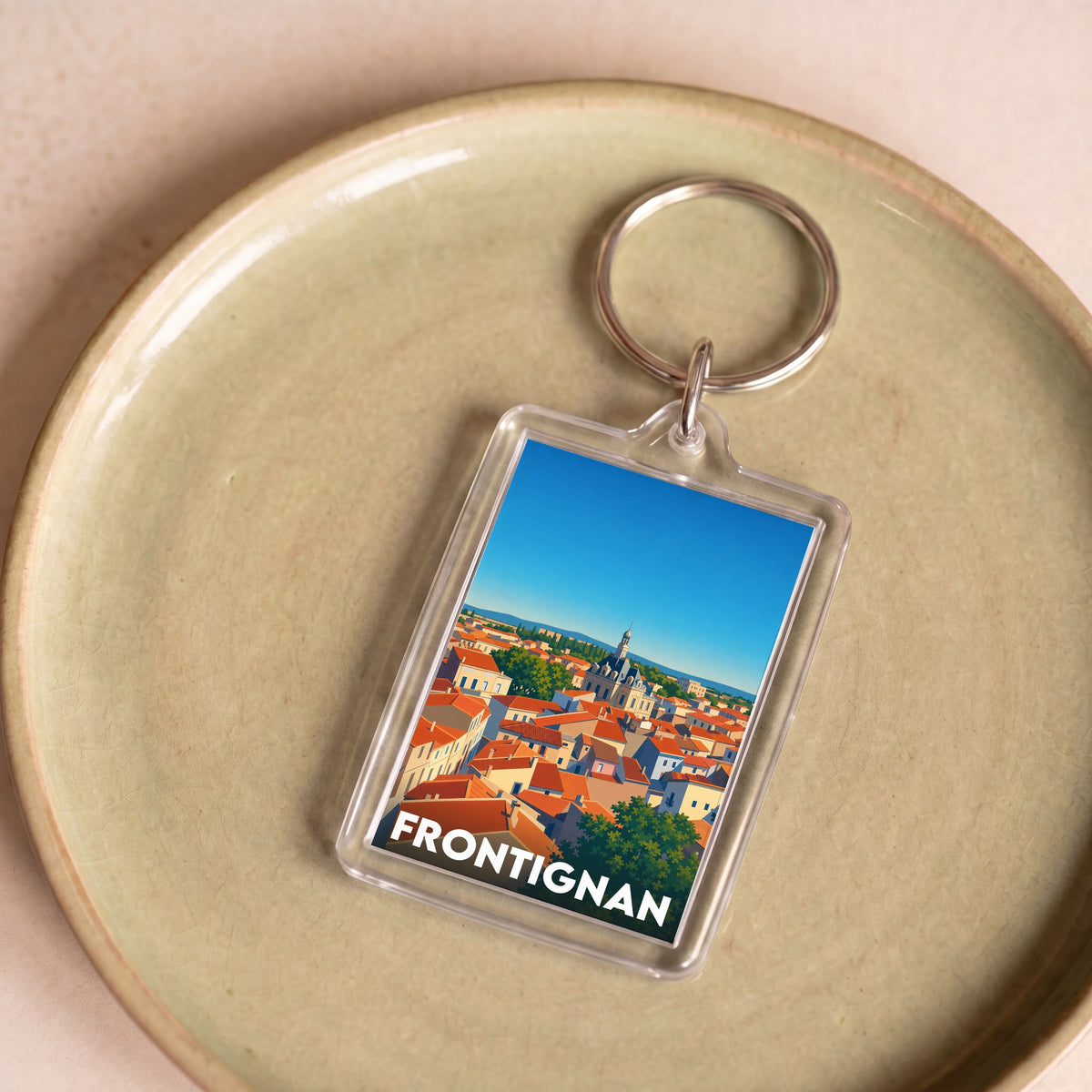 Porte-clés souvenir de la ville de Frontignan avec une illustration stylisée.