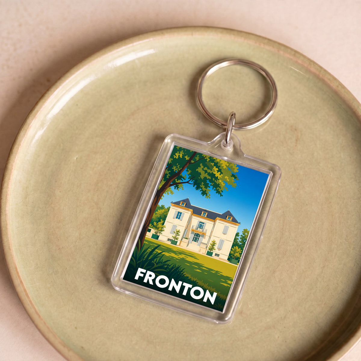 Porte-clés souvenir de la ville de Fronton avec une illustration stylisée d'une demeure bourgeoise.