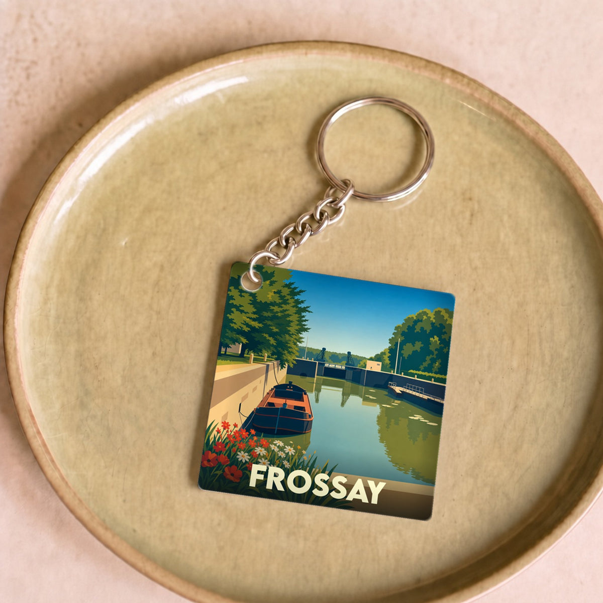 Porte-clés souvenir de la ville de Frossay avec une illustration stylisée d'un canal et de son écluse.