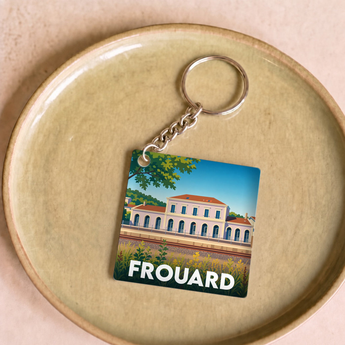 Porte-clés souvenir de la ville de Frouard avec une illustration stylisée de sa gare.