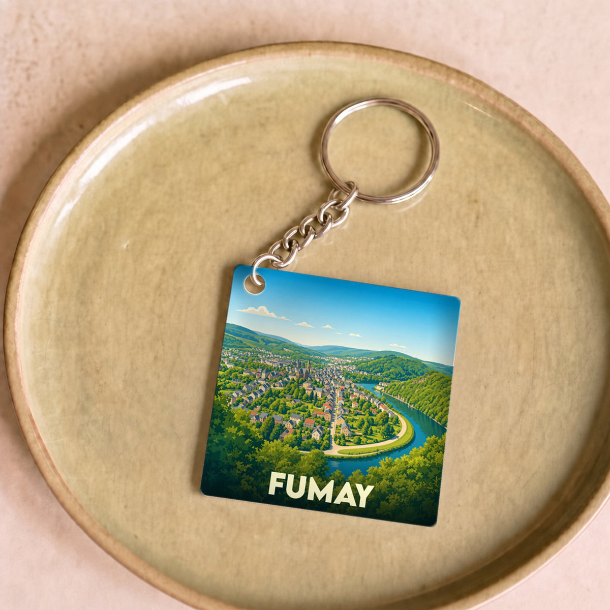 Porte-clés souvenir de la ville de Fumay avec une illustration stylisée d'un méandre de la Meuse.