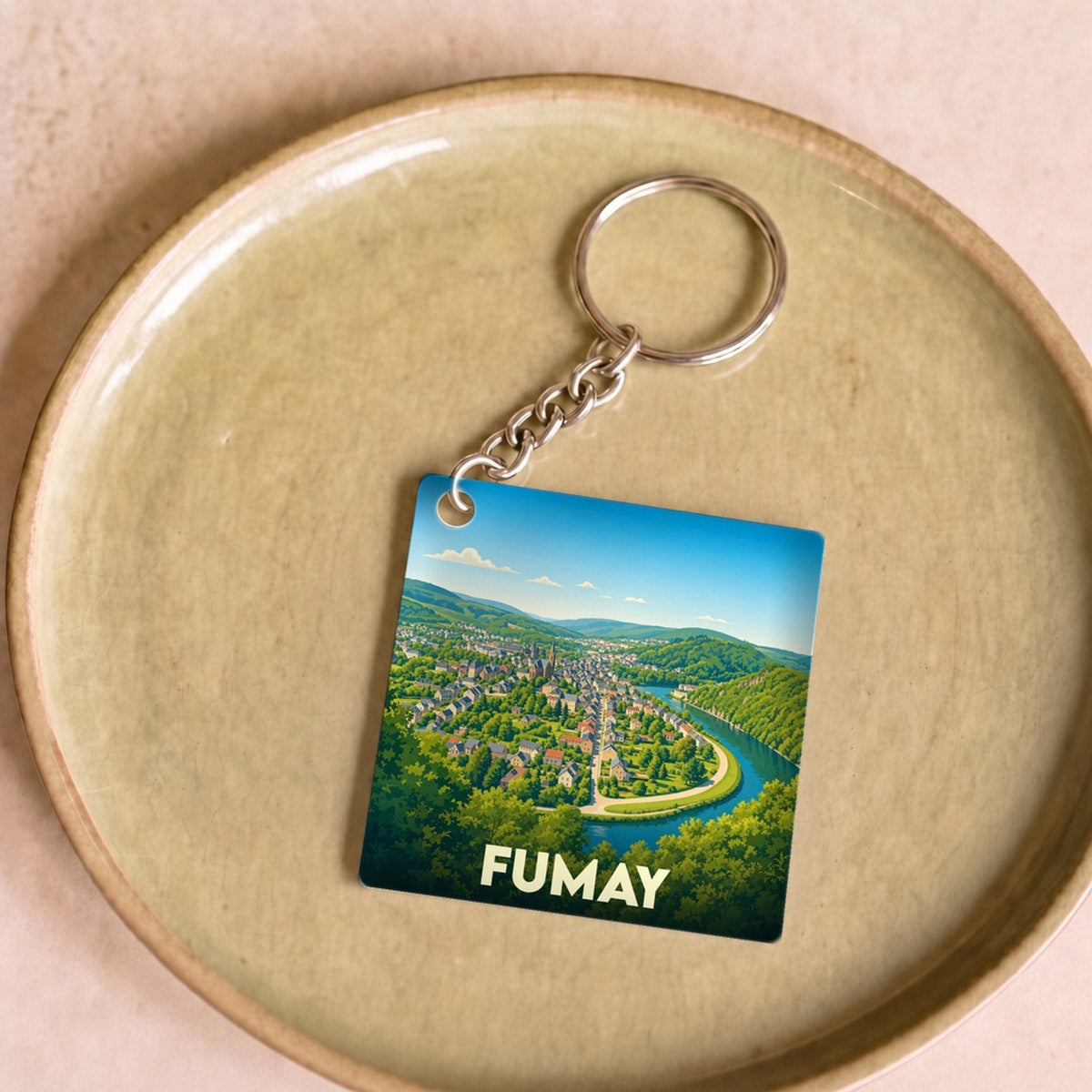 Porte-clés souvenir de la ville de Fumay avec une illustration stylisée d'un méandre de la Meuse.
