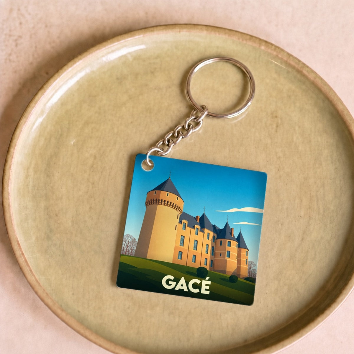 Porte-clés souvenir de la ville de Gacé avec une illustration stylisée de son château.