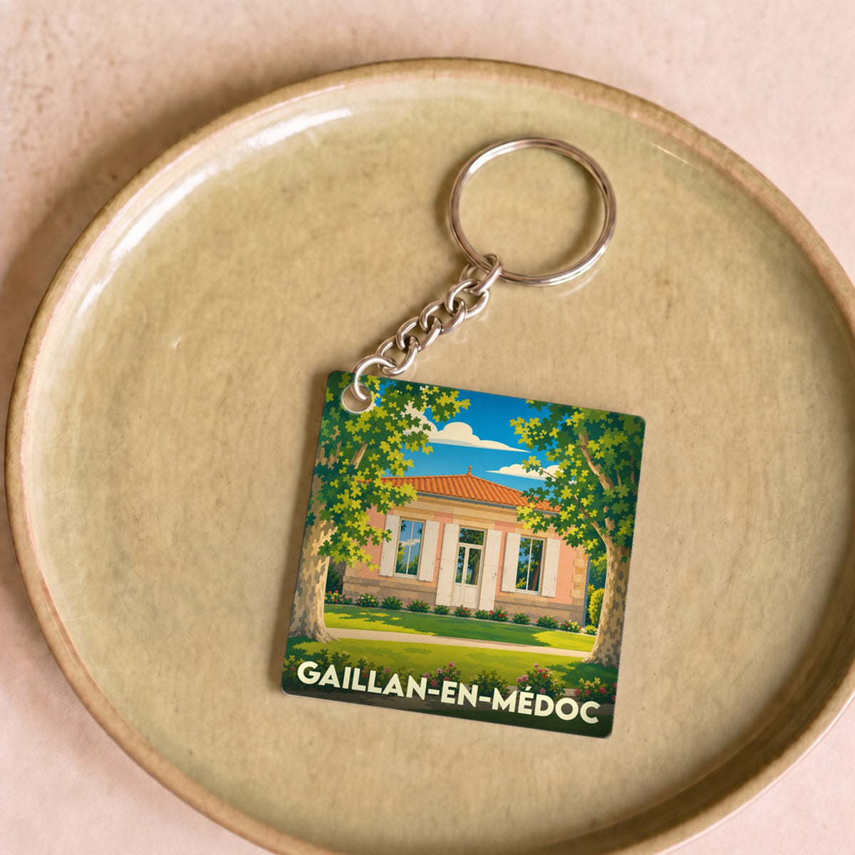 Porte-clés souvenir de la ville de Gaillan-en-Médoc avec une illustration stylisée d'une maison locale.