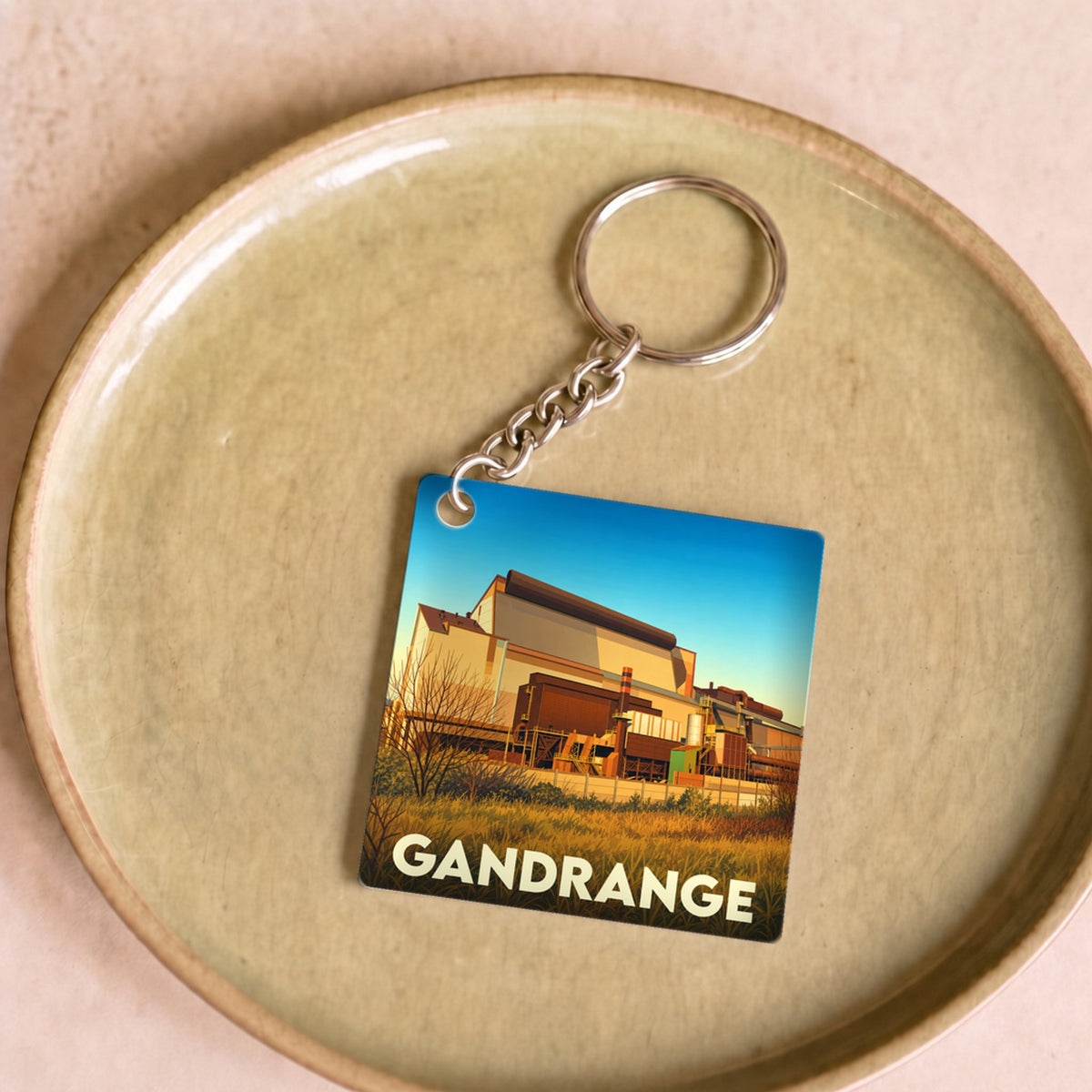 Porte-clés souvenir de la ville de Gandrange avec une illustration stylisée de son patrimoine industriel.