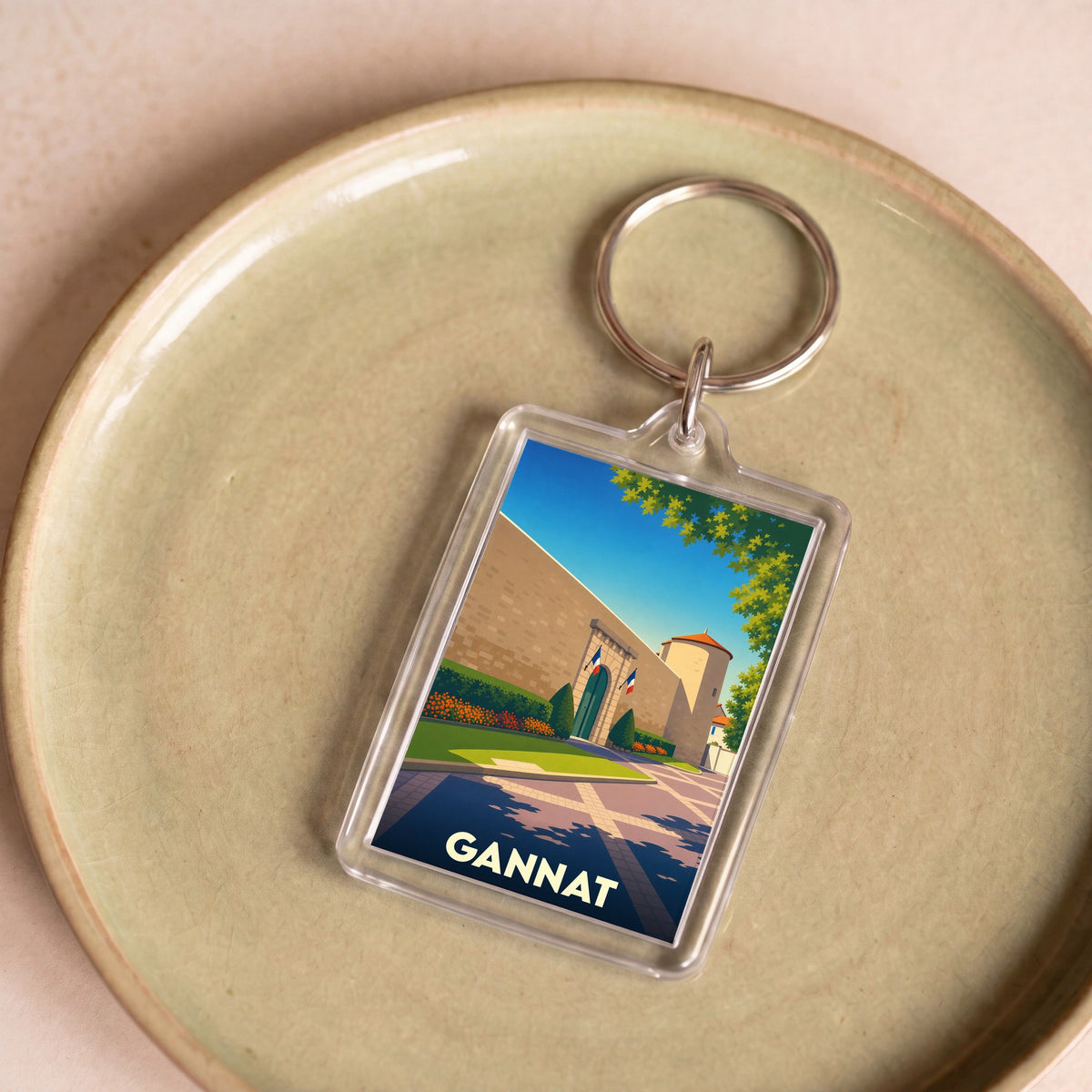 Porte-clés souvenir de la ville de Gannat avec une illustration stylisée de son château.