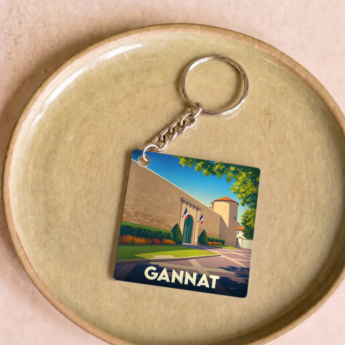 Porte-clés souvenir de la ville de Gannat avec une illustration stylisée de son château.