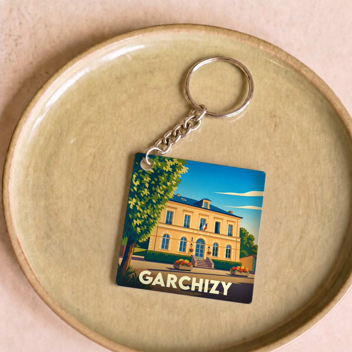 Porte-clés souvenir de la ville de Garchizy avec une illustration stylisée de sa mairie.