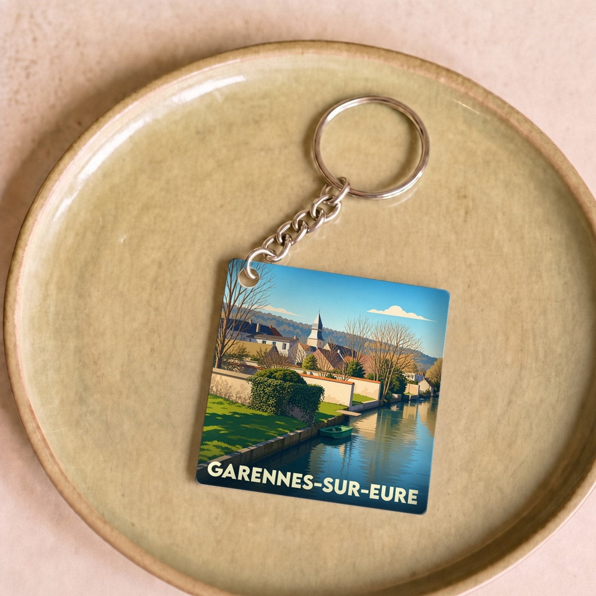Porte-clés souvenir de la ville de Garennes-sur-Eure avec une illustration stylisée.