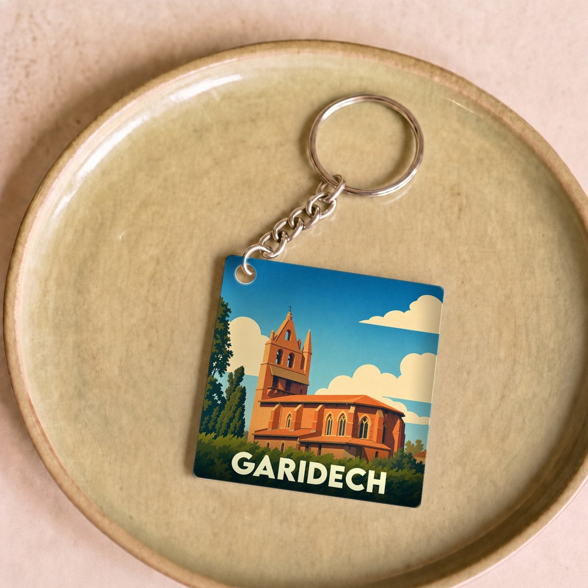 Porte-clés souvenir de la ville de Garidech avec une illustration stylisée de son église.