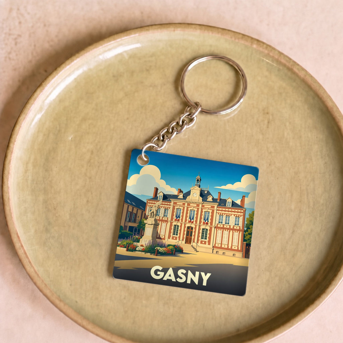 Porte-clés souvenir de la ville de Gasny avec une illustration stylisée de son hôtel de ville.