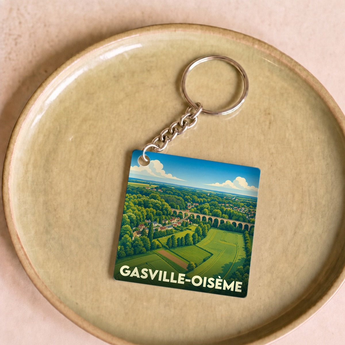 Porte-clés souvenir de la ville de Gasville-Oisème avec une illustration stylisée d'un viaduc et de paysages verdoyants.
