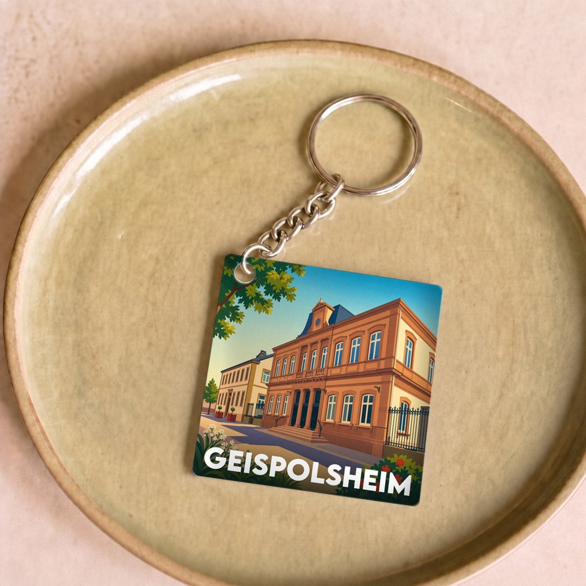 Porte-clés souvenir de la ville de Geispolsheim avec une illustration stylisée.