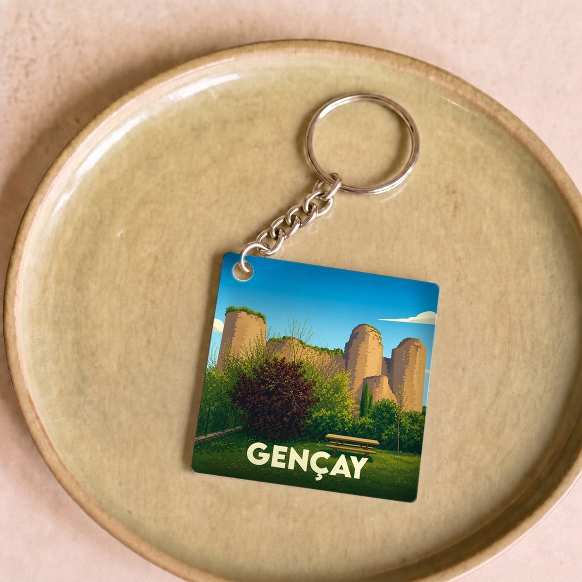 Porte-clés souvenir de la ville de Gençay avec une illustration stylisée de son château.