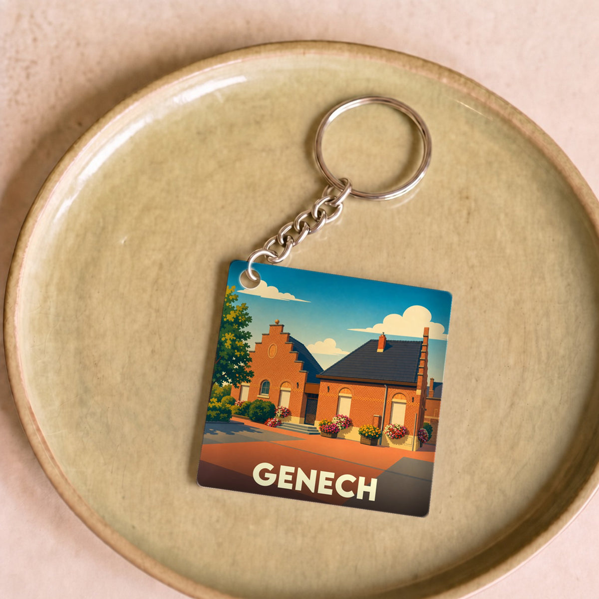 Porte-clés souvenir de la ville de Genech avec une illustration stylisée d'une maison traditionnelle.