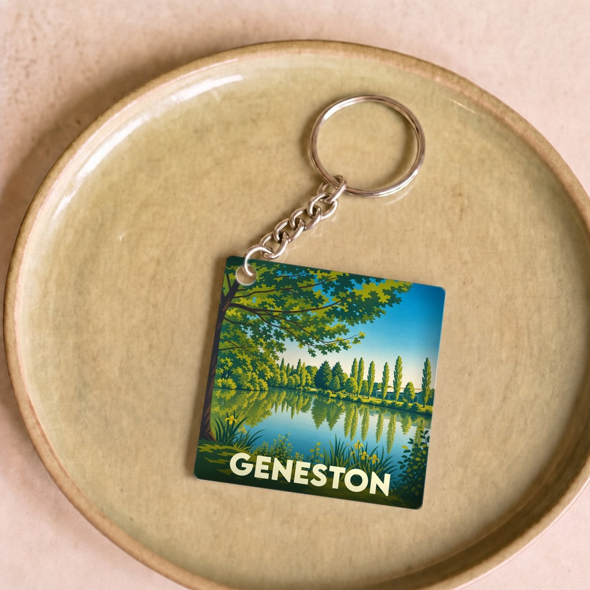 Porte-clés souvenir de la ville de Geneston avec une illustration stylisée d'un paysage de lac.