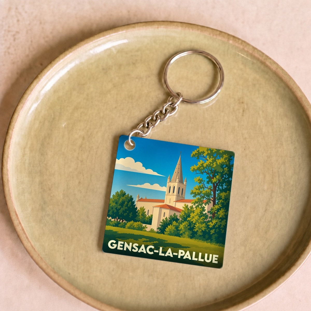Porte-clés souvenir de la ville de Gensac-la-Pallue avec une illustration stylisée de son église.