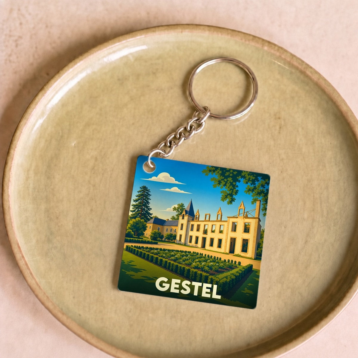 Porte-clés souvenir de la ville de Gestel avec une illustration stylisée de son château.