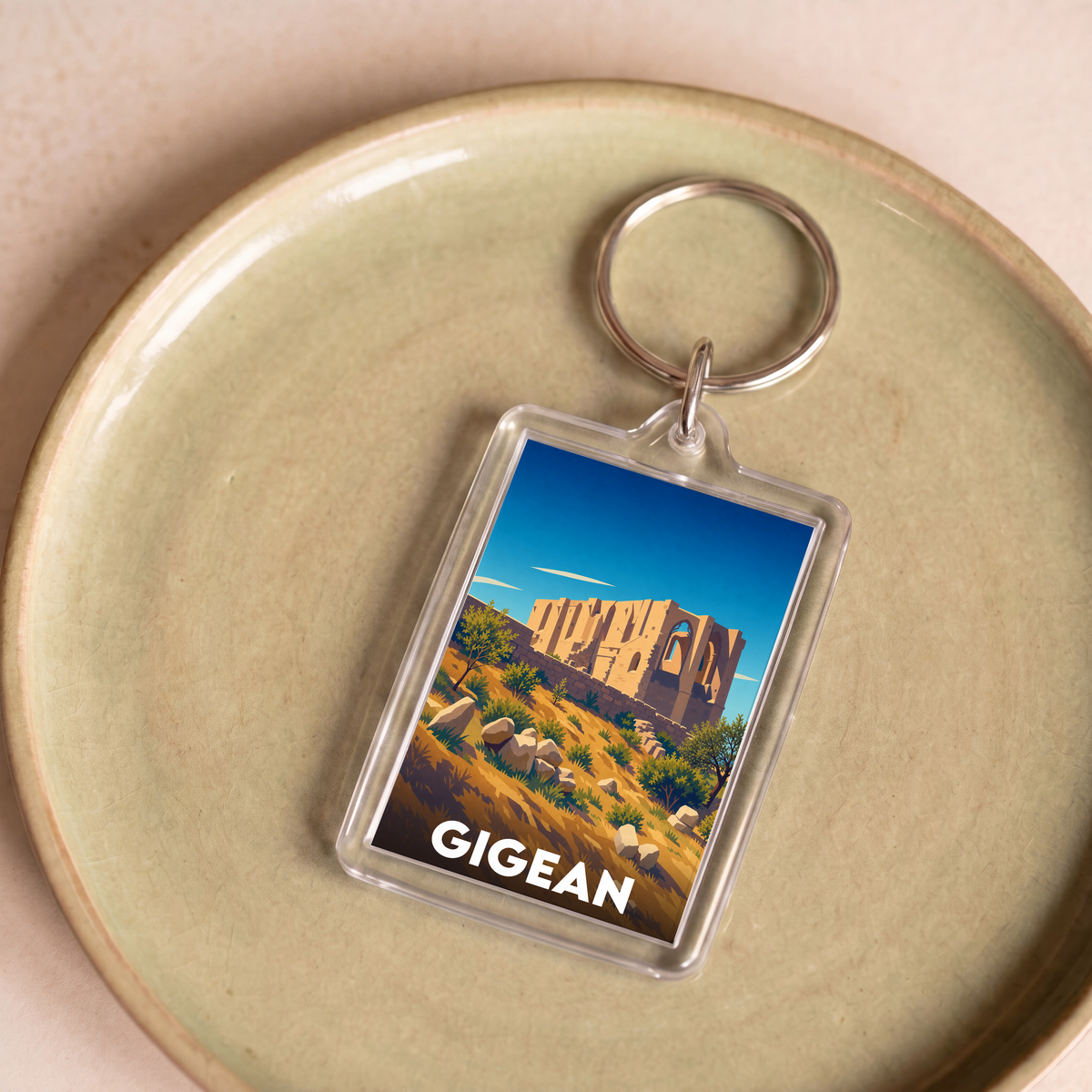 Porte-clés souvenir de la ville de Gigean avec une illustration stylisée de l'abbaye Saint-Félix-de-Montceau.